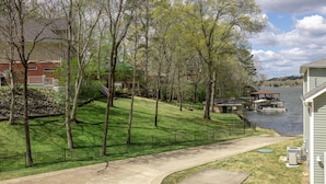 Un quartier résidentiel avec une rivière, un quai et une maison dotée d’une pelouse verdoyante et de quelques arbres.