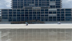 Un edificio moderno con techo plano y varios pisos, destacando un letrero grande con la leyenda 'Moontide'.