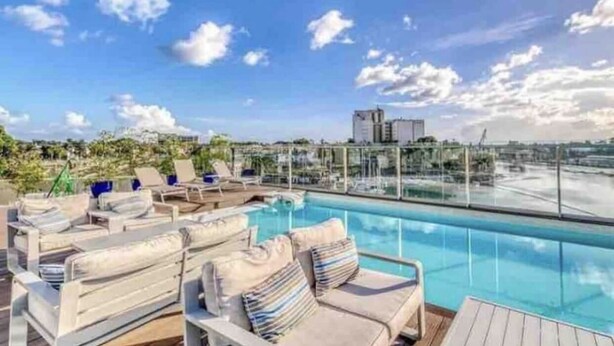 A rooftop pool area with lounge chairs and a clear view of the city skyline. - Amazing view at Riviera Colonial & zona Colonial (Villa Duarte)
