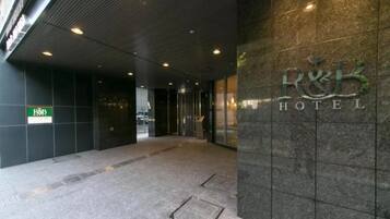 Enter the R&B Hotel through its sleek entrance, flanked by glass doors and a tiled floor.