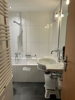 Une salle de bain moderne avec une baignoire, une douche et un lavabo.