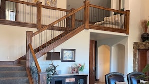A spacious living area with a wooden staircase, a fireplace, and a seating area with a coffee table. - Luxury home with breathtaking  views, 10 min. to Mayflower Resort, 15 to gondola (Heber City)