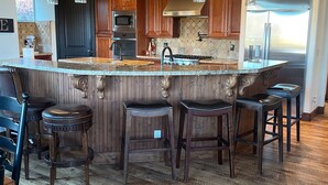 A spacious kitchen with a large island, wooden cabinets, stainless steel appliances, and pendant lighting. - Luxury home with breathtaking  views, 10 min. to Mayflower Resort, 15 to gondola (Heber City)