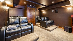 A home theater room with leather recliners, carpeted flooring, wooden paneling, and recessed lighting. - Luxury home with breathtaking  views, 10 min. to Mayflower Resort, 15 to gondola (Heber City)