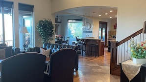 A spacious living area with a high ceiling, a dining area, and a kitchen in the background. - Luxury home with breathtaking  views, 10 min. to Mayflower Resort, 15 to gondola (Heber City)