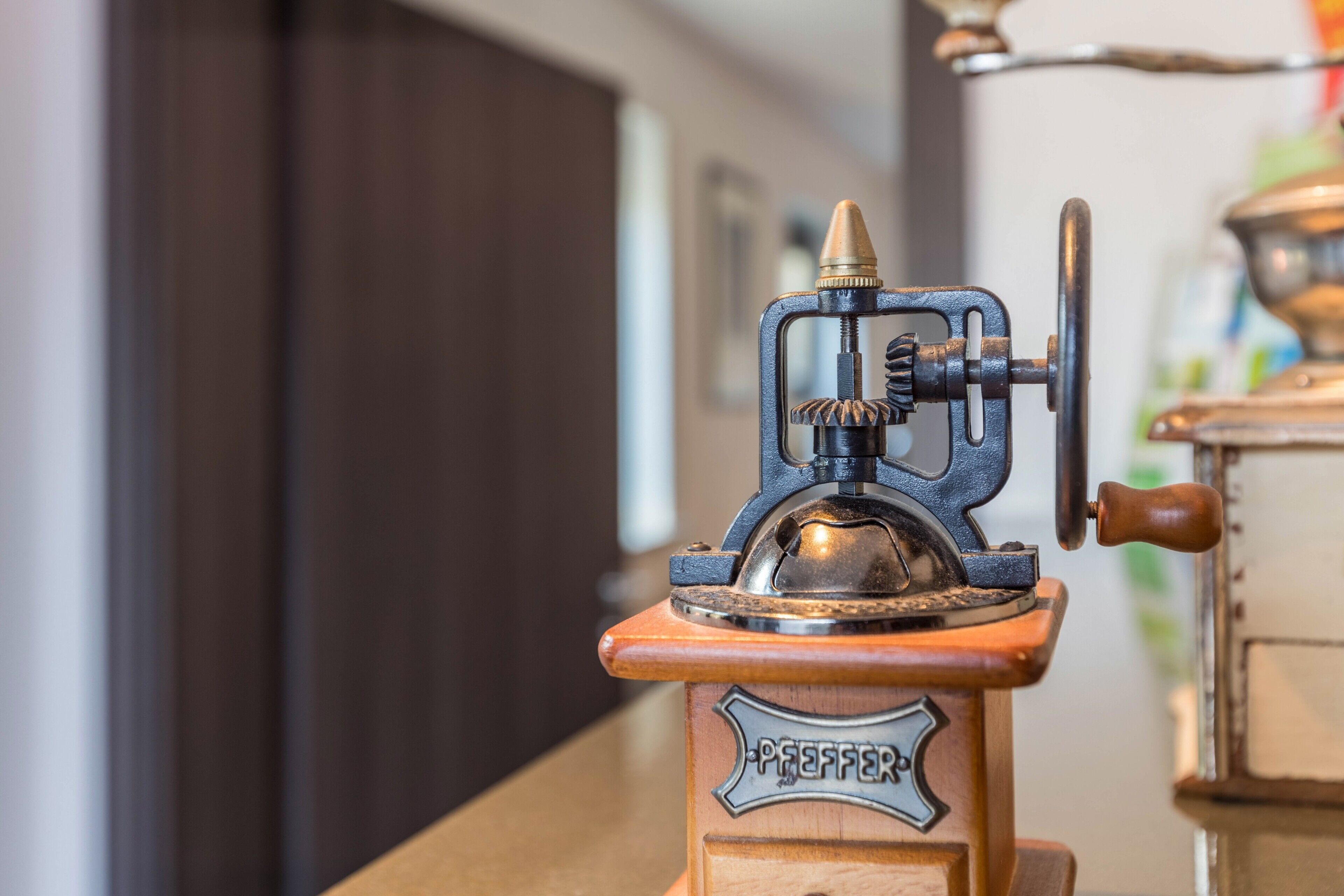 A vintage coffee grinder with a wooden base and metal components.