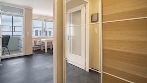 A modern hotel room with a large window, a desk, and a chair.