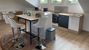 Une cuisine moderne avec un coin repas, une poubelle et une fenêtre donnant sur un beau paysage.