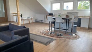 Une chambre moderne de style loft, comprenant un coin repas, un canapé et une cuisine.