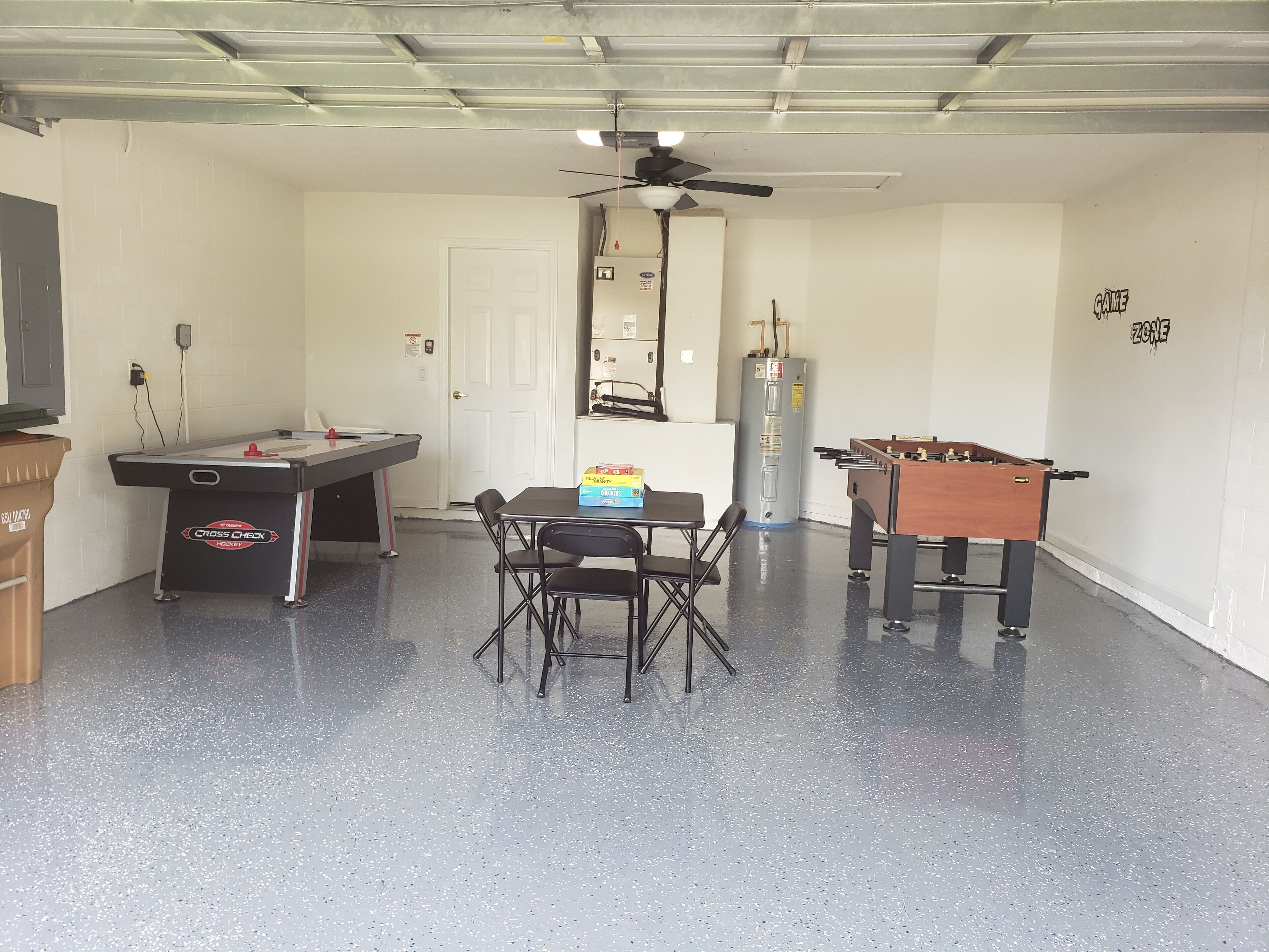 A room with a pool table, a foosball table, and a table with snacks.
