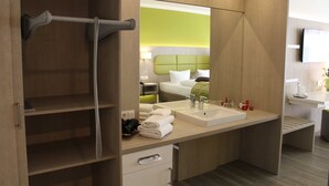 Een moderne hotelbadkamer met een grote spiegel, een wastafel en een handdoekhouder.
