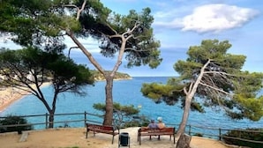 Ein Küstenpark mit Bänken und freiem Blick auf das Meer.