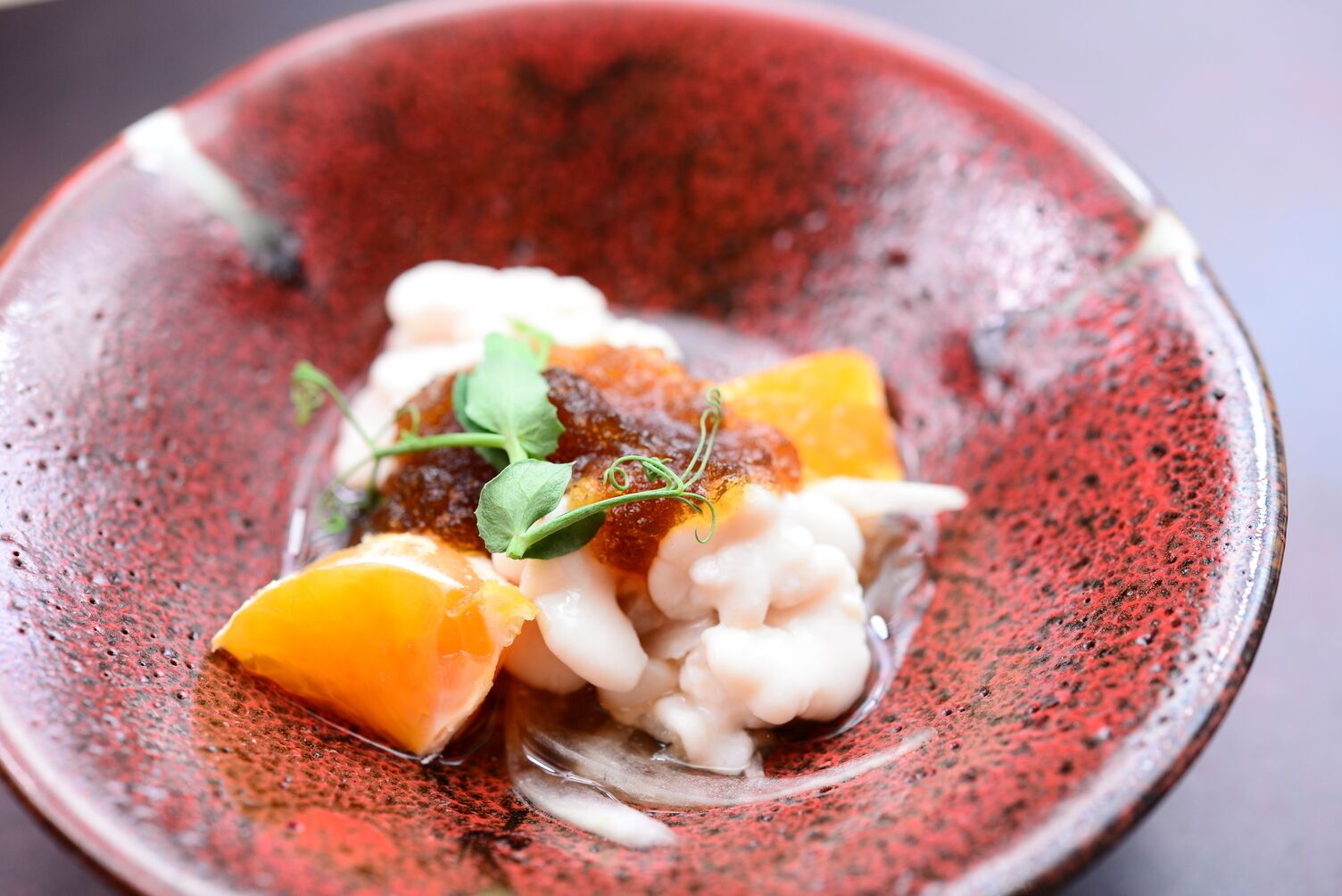 A bowl of food with a red speckled pattern.