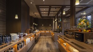 A modern hotel lobby with wooden flooring, a central reception desk, and various amenities like coffee machines and a fruit display. - Hotel Route-Inn Yonago (Yonago)