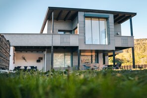 A modern two-story house with a flat roof, large windows, and a balcony. - Landart Appartement one (Tirol)