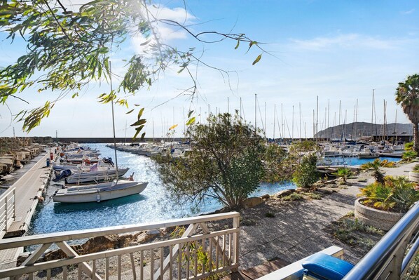 A marina with boats docked, a wooden walkway, and a view of the water.