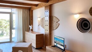 Une chambre moderne avec un plafond en bois, une grande fenêtre avec des rideaux, un meuble en bois, une petite table avec un téléviseur et un élément décoratif mural.