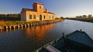 A rustic building with a tower, situated by a calm river. - Luisa 5B - Cozy three rooms apartment (Lido di Pomposa)