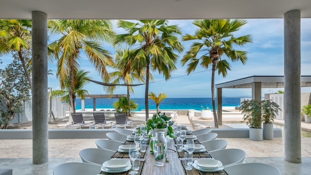 Mesa de comedor para seis personas con vista a la playa y al océano.