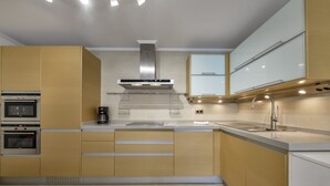 A modern kitchen with built-in ovens, a stainless steel range hood, a sink, and a coffee maker. - MARJALETA, Beautiful apartment in the centre of Moraira for 4 pax free wifi. (Moraira)