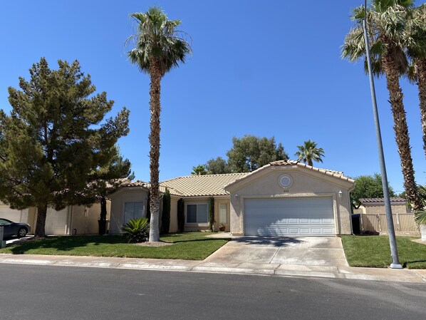 A single-story house with a garage, surrounded by palm trees and a well-maintained lawn. - Mesquite Retreat 3 Bedroom, 2 Bath with pool! Pool is NOT HEATED. (Mesquite)