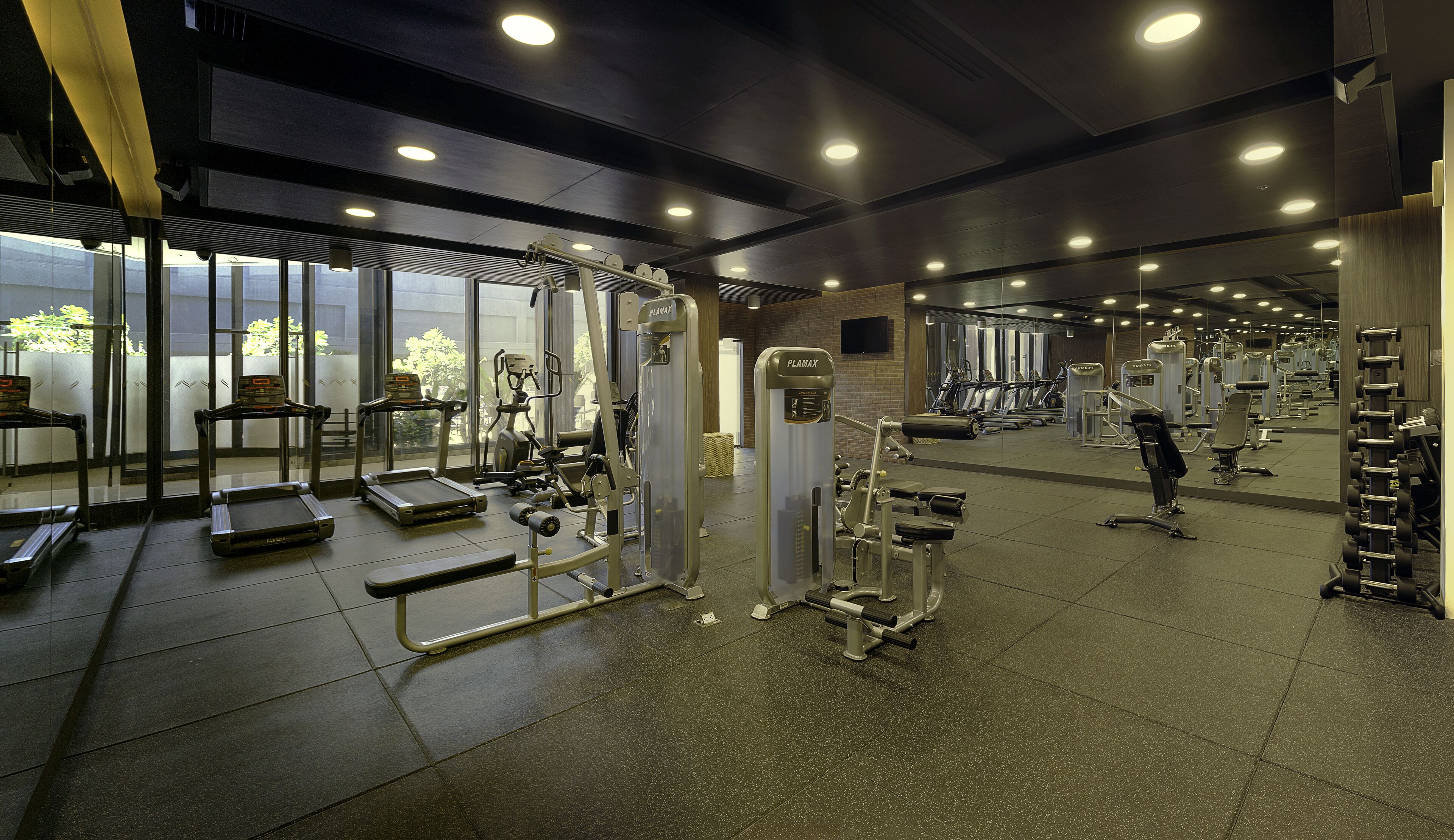 A gym with various exercise equipment, including treadmills, weight machines, and free weights.