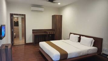 Una habitación de hotel con cama, escritorio y armario.