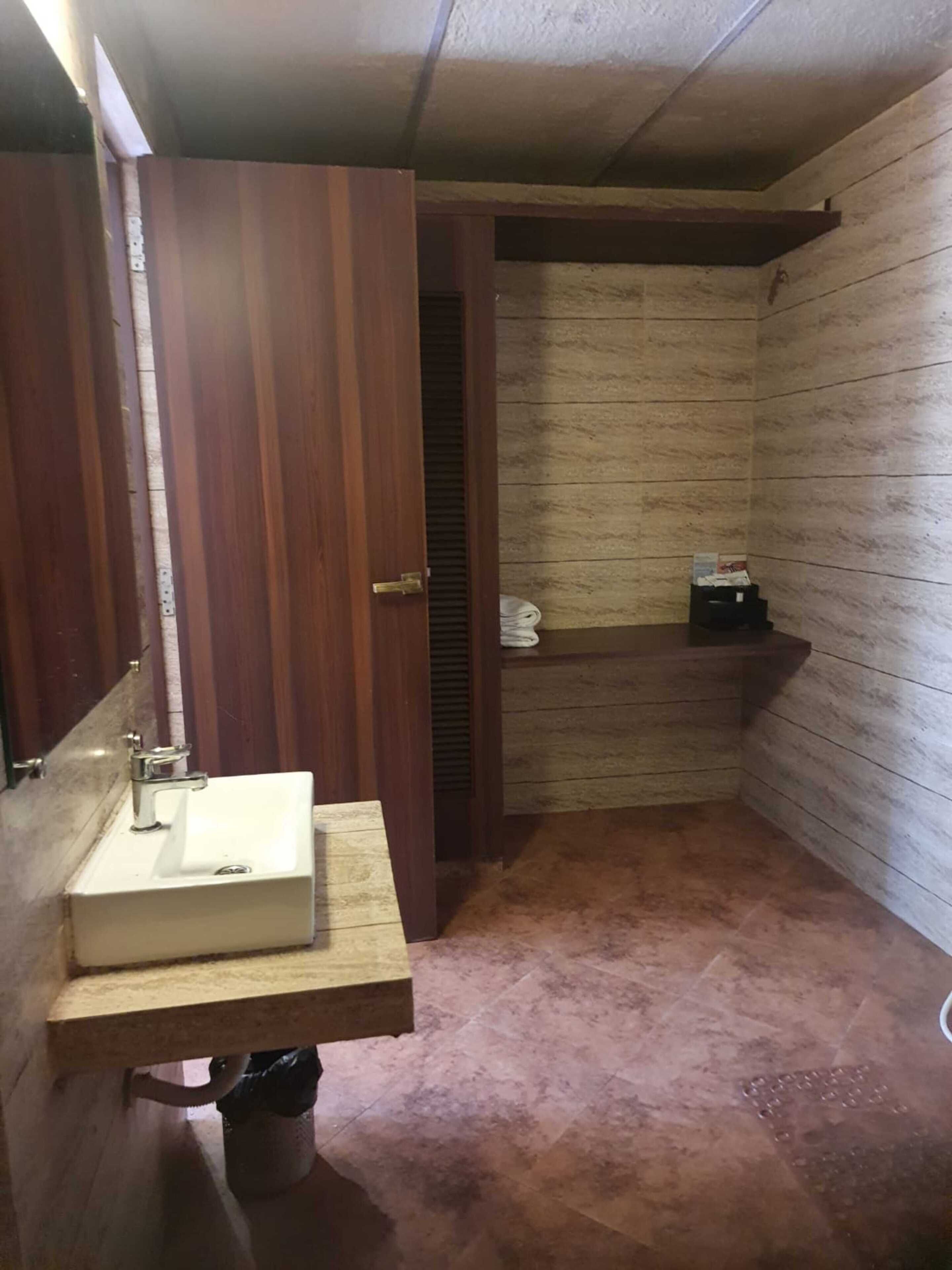 A bathroom with a wooden vanity, a sink, and a towel rack.