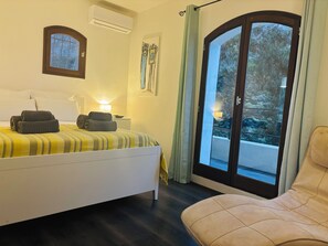 A hotel room with a bed, a chair, a window with curtains, and a view of the outdoors. - Villa-Monti, Menton, Côte d'Azur (Menton)