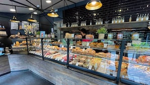 A bakery display case filled with various baked goods and a person browsing. - Villa Monti: Luxury Villa, Large Pool, Air Con, Amazing Views (Menton)