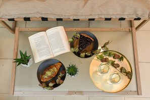 A wooden tray with a book, a slice of pie, a plate with a drink, and a small plant. - Vacation Feel (Bucharest)