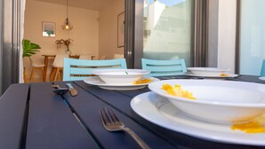 A dining table with plates, cutlery, and a bowl with remnants of food. - Magnifico apartamento a 1 min de la playa (Barbate)