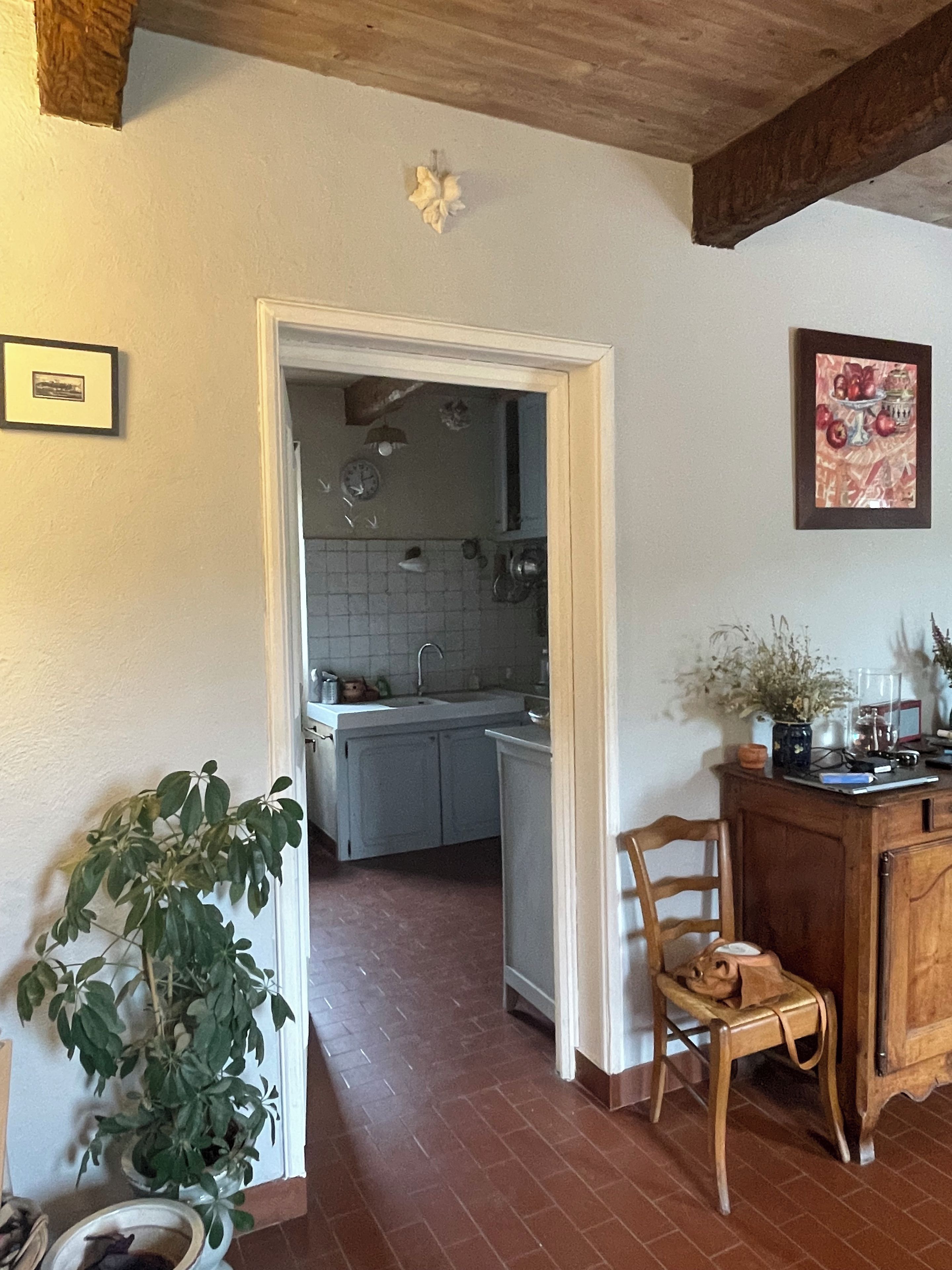 A kitchen with a sink, cabinets, and a wooden chair.