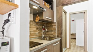 A kitchen with a built-in microwave, a sink, and a wooden cabinet.