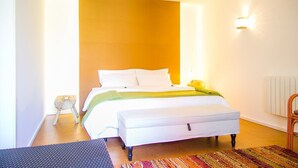 A modern bedroom with a large bed, a bedside table, a chair, and a floor lamp. - Garden Pool House by Liiiving (Porto)