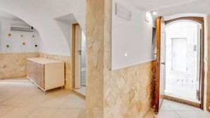 A room with a stone wall, a wooden door, and a white cabinet. - GuestHost - Lovely apartment located in the heart of Monopoli, in the historic center, in a stone building of which it retains suggestive evidences in the internal architecture. The flat can comfortably accommodate two people and is located in an enviabl (Monopoli)