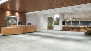 A spacious lobby with a reception desk, seating area, and a large wall-mounted artwork.