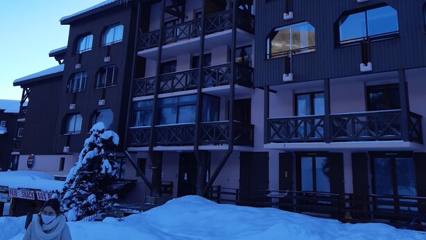 A multi-story hotel with balconies and large windows, surrounded by snow. - Apartment 40m2 (La Foux d'Allos)