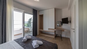 A modern hotel room with a bed, a desk, a chair, and a balcony with a view. - New Luxury Modern Four-bedroom Villa With Pool (Kastela)