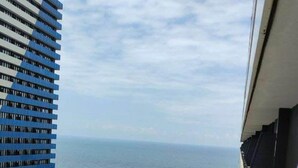 A high-rise building with a view of the sea and a beach below. - Orbi City Batumi Apartment With sea Views (Batumi)