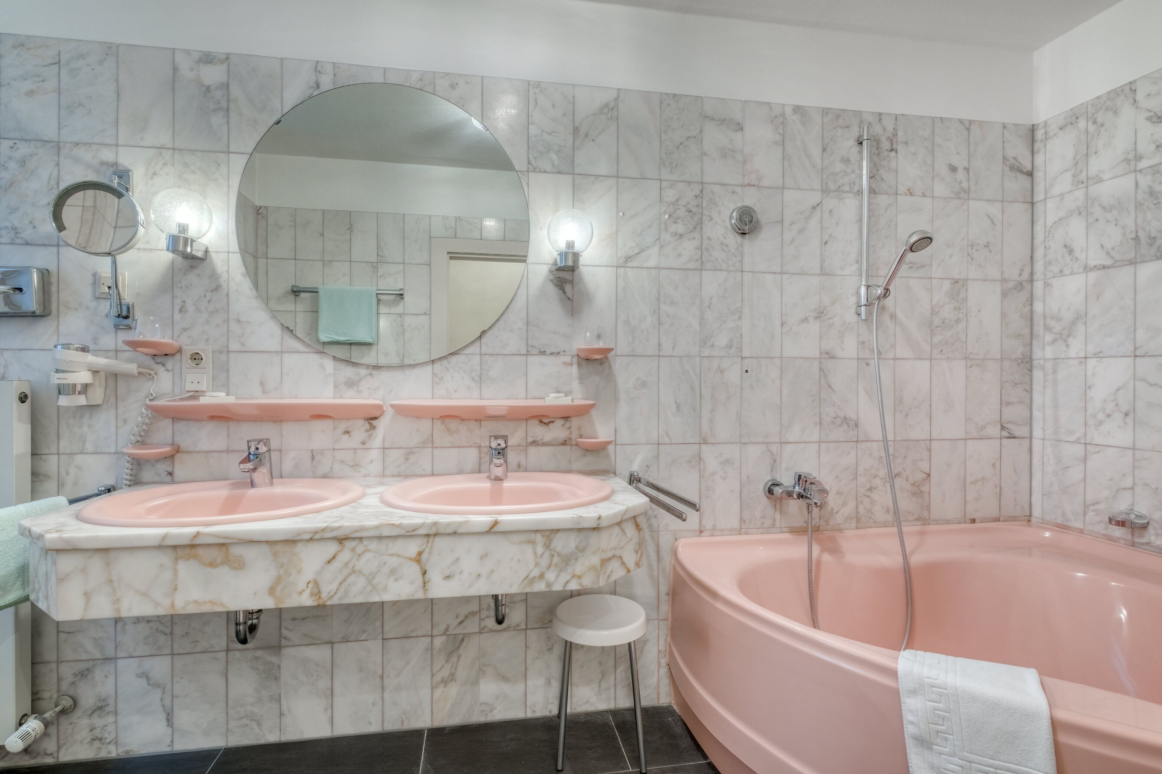 Ein Badezimmer mit zwei Waschbecken, einem großen Spiegel, einer Badewanne und einer Dusche.