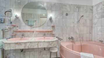 Ein Badezimmer mit zwei Waschbecken, einem großen Spiegel, einer Badewanne und einer Dusche.