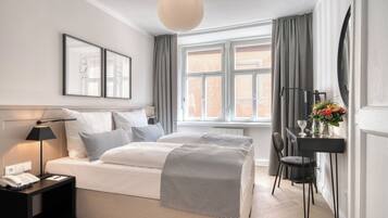 Un dormitorio moderno con cama, mesita de noche, lámpara y ventana con cortinas.