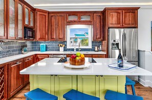 Enjoy cooking in this well-equipped kitchen with a central island, sink, and ample storage.