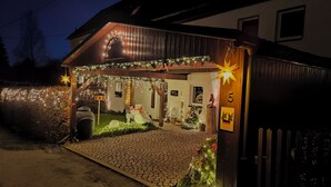 A house with a covered porch decorated with lights and a star.