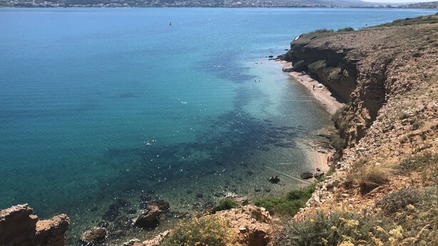 A coastal landscape with clear blue waters, rocky cliffs, and a distant cityscape. - Holiday Apartment of Your Dreams a2a (Pag)