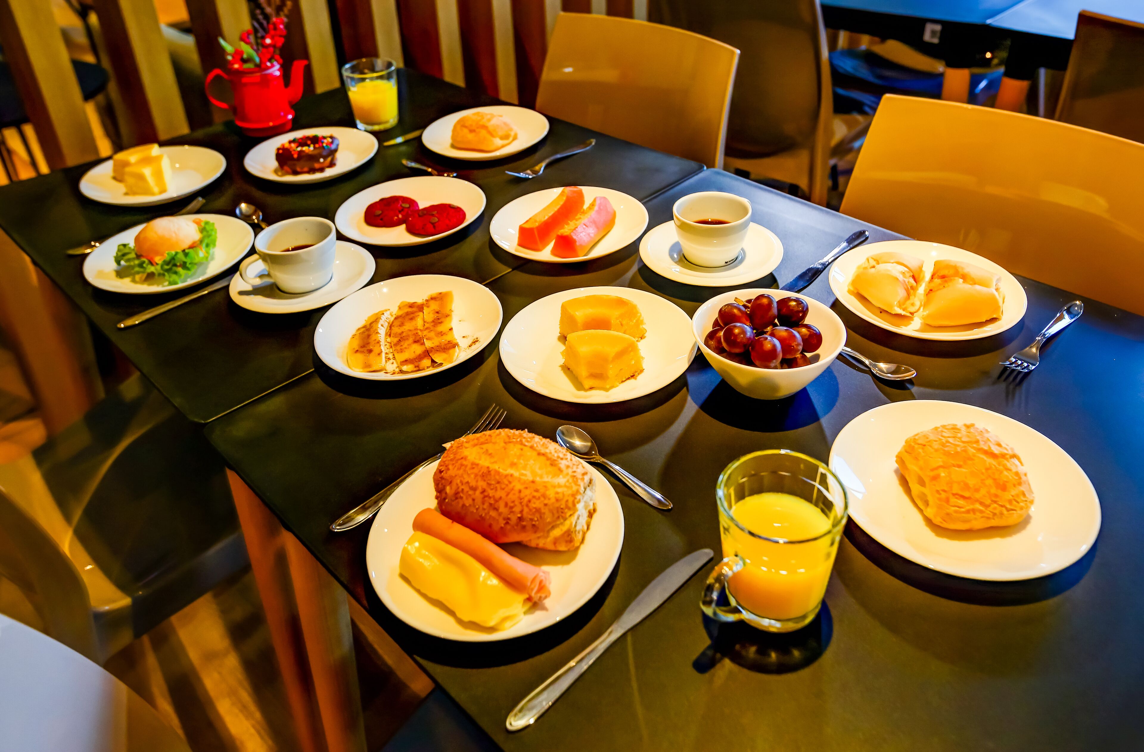 A breakfast table with various dishes, including eggs, toast, and fruit.
