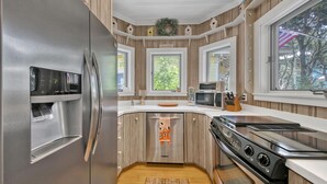 A modern kitchen with a stainless steel refrigerator, microwave, and stove. - Seaside "Frose Rose" | 2 BR | Sleeps 6 | Private | Steps to Beach! (Santa Rosa Beach)