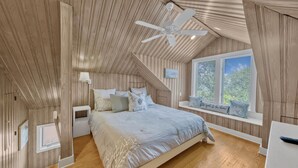A bedroom with a sloped ceiling, a bed with multiple pillows, a bedside table, a window with blinds, and a ceiling fan. - Seaside "Frose Rose" | 2 BR | Sleeps 6 | Private | Steps to Beach! (Santa Rosa Beach)