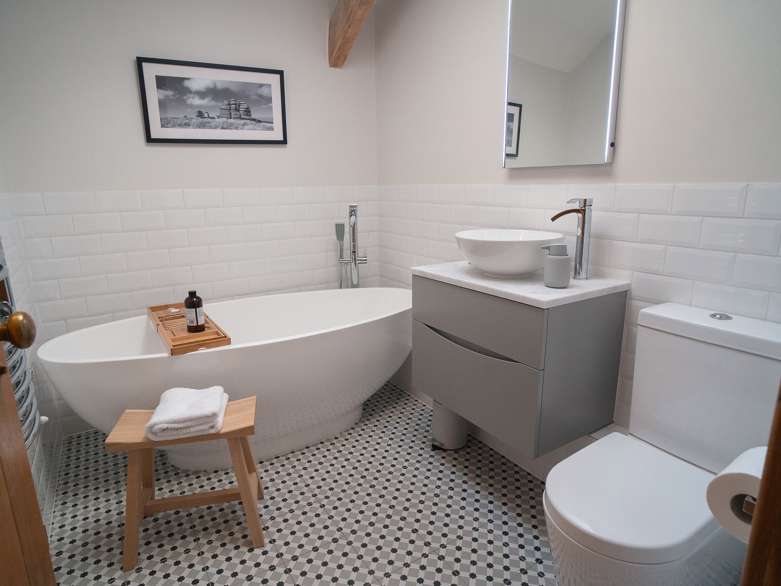 Un baño moderno con una bañera independiente, un tocador con lavamanos y un inodoro.